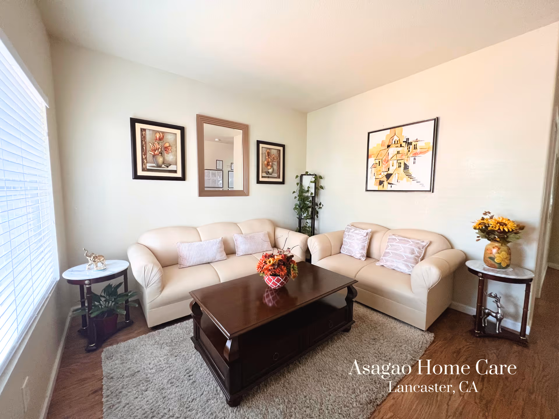 Bright living room with two beige sofas, a wooden coffee table, wall art, and side tables.