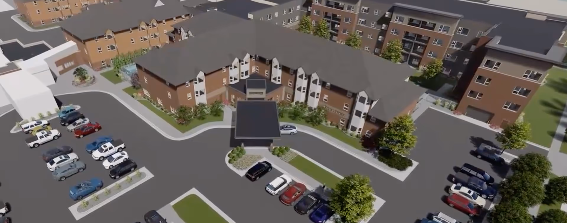 Aerial view of a senior living facility named The Linden, showing multiple connected buildings with brown roofs and beige walls, surrounded by parking lots with several parked cars and landscaped areas with trees and shrubs.