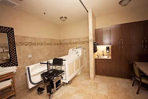 Interior of a senior care bathroom with an accessible tub and dark cabinetry.