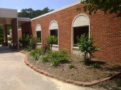 Westwood Manor brick building exterior with arched windows and landscaped front yard.