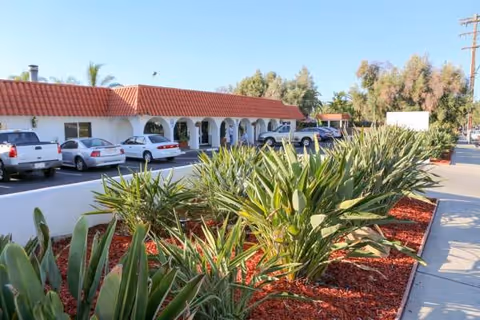 Exterior view of Victoria Post Acute Care with arches, parked cars, and landscaped front.
