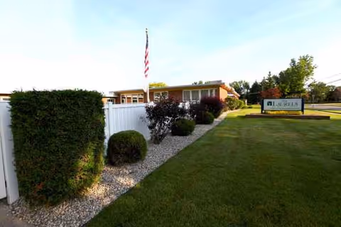 Exterior view of Laurels of Mt Pleasant with a manicured lawn and front sign.