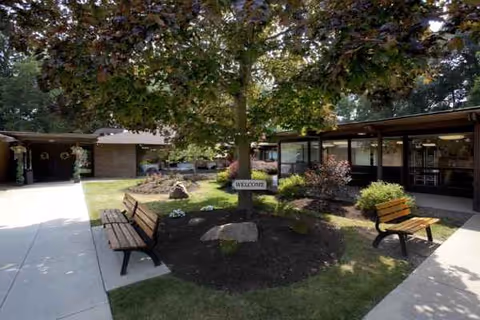 An outdoor courtyard at Altercare Cuyahoga Falls features benches and greenery.