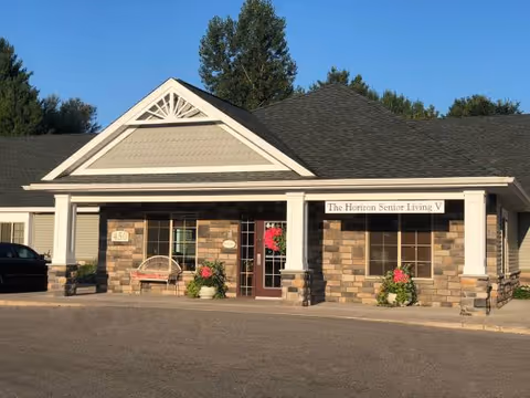 Front view of The Horizon Senior Living building with entrance and planters.