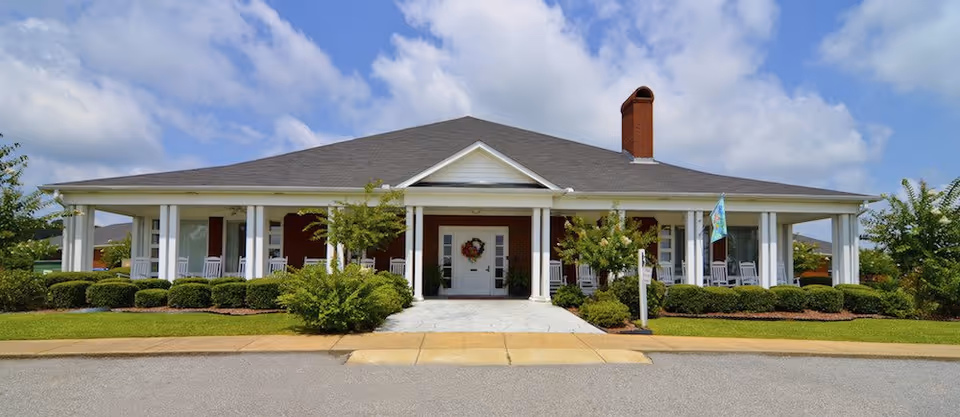 Front view of a single-story, columned senior living facility with a wreath.