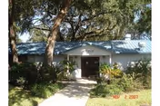 Single-story building with a light blue metal roof and white exterior walls, surrounded by trees and bushes. A concrete walkway leads to the entrance with double doors. The date stamp on the bottom right corner reads Nov 2 2007.