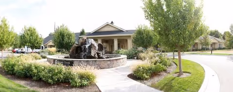 Exterior view of Edgewood Spring Creek Overland with fountain, trees, and landscaped entry.