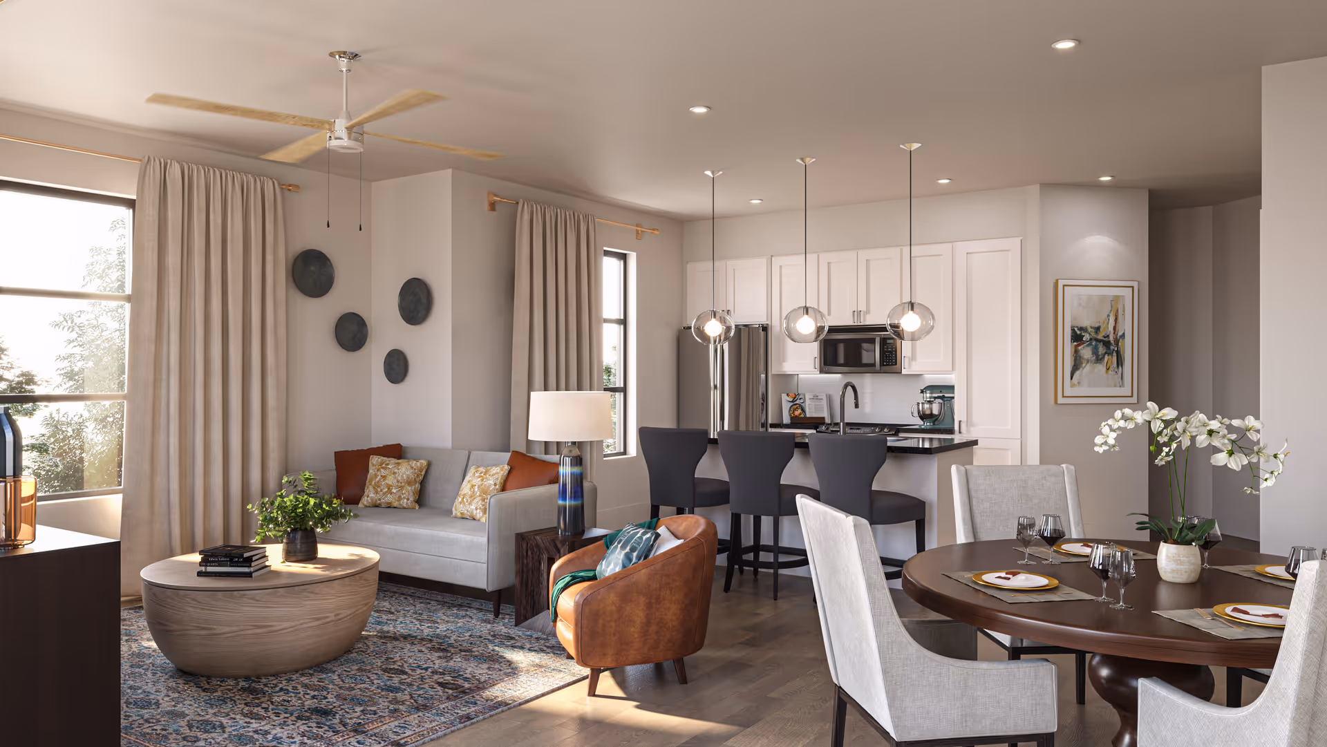 Open-plan living and dining area with a sofa, armchair, round coffee table, dining table, and a kitchen island with barstools.