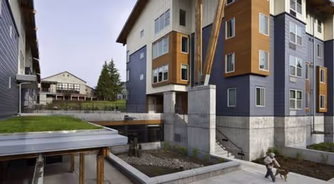 Exterior view of Creekside Woods senior living building with stairs and courtyard.