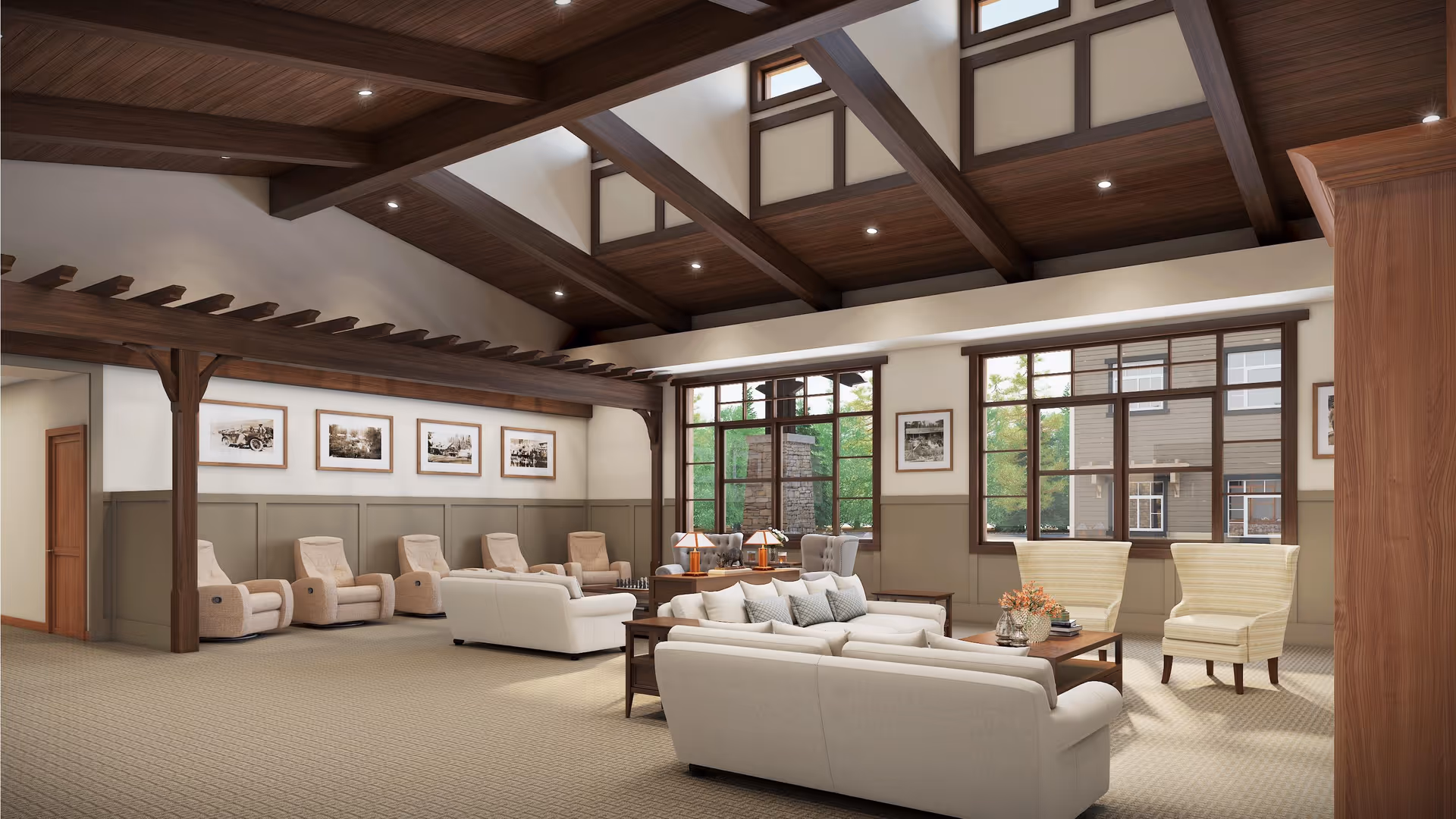 A spacious and well-lit living room area with high wooden beam ceilings and large windows letting in natural light. The room features comfortable beige sofas, armchairs, and recliners arranged around wooden coffee tables. The walls are decorated with framed black and white photographs, and the carpet is a neutral tone. The overall atmosphere is warm and inviting.