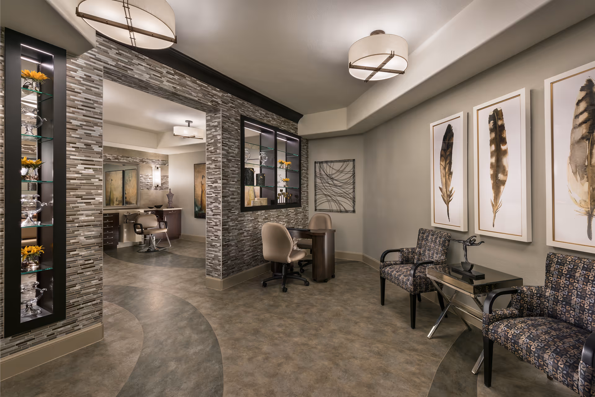 Modern interior common area with seating, a small reception desk, decorative feather artwork, and a view into a salon space.