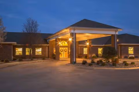 Oak Manor Nursing Center entrance with warm lights and a covered drive-up entry at dusk.
