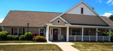Single-story senior living facility with a covered front porch and well-kept lawn.