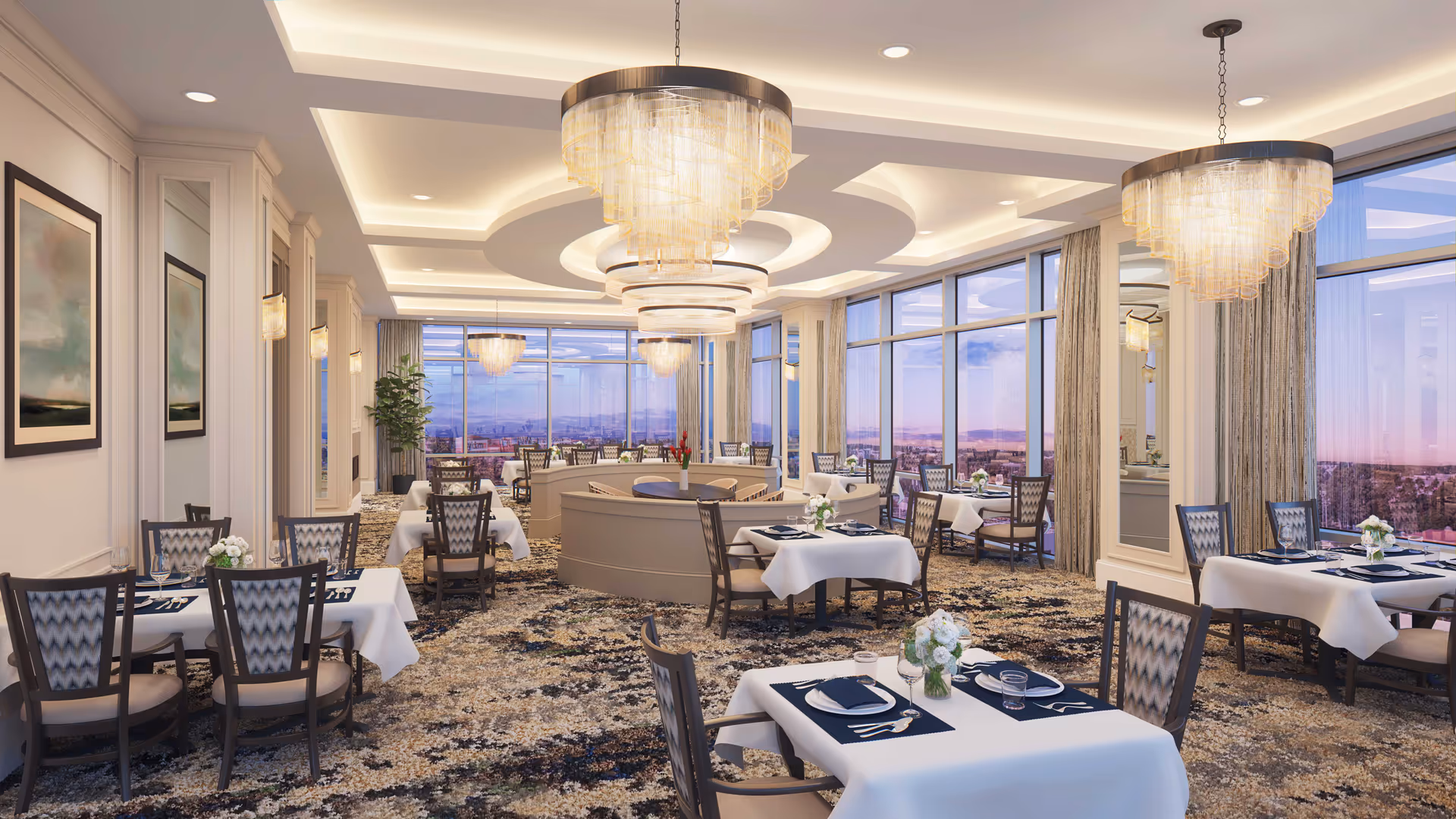 Elegant dining room with multiple tables covered in white tablecloths, each set with plates, glasses, and silverware. The room features large windows with a scenic view outside, patterned carpet, decorative wall art, and modern chandeliers hanging from a detailed ceiling.