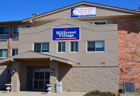 Front view of Hillcrest Village senior living facility with entrance and sign