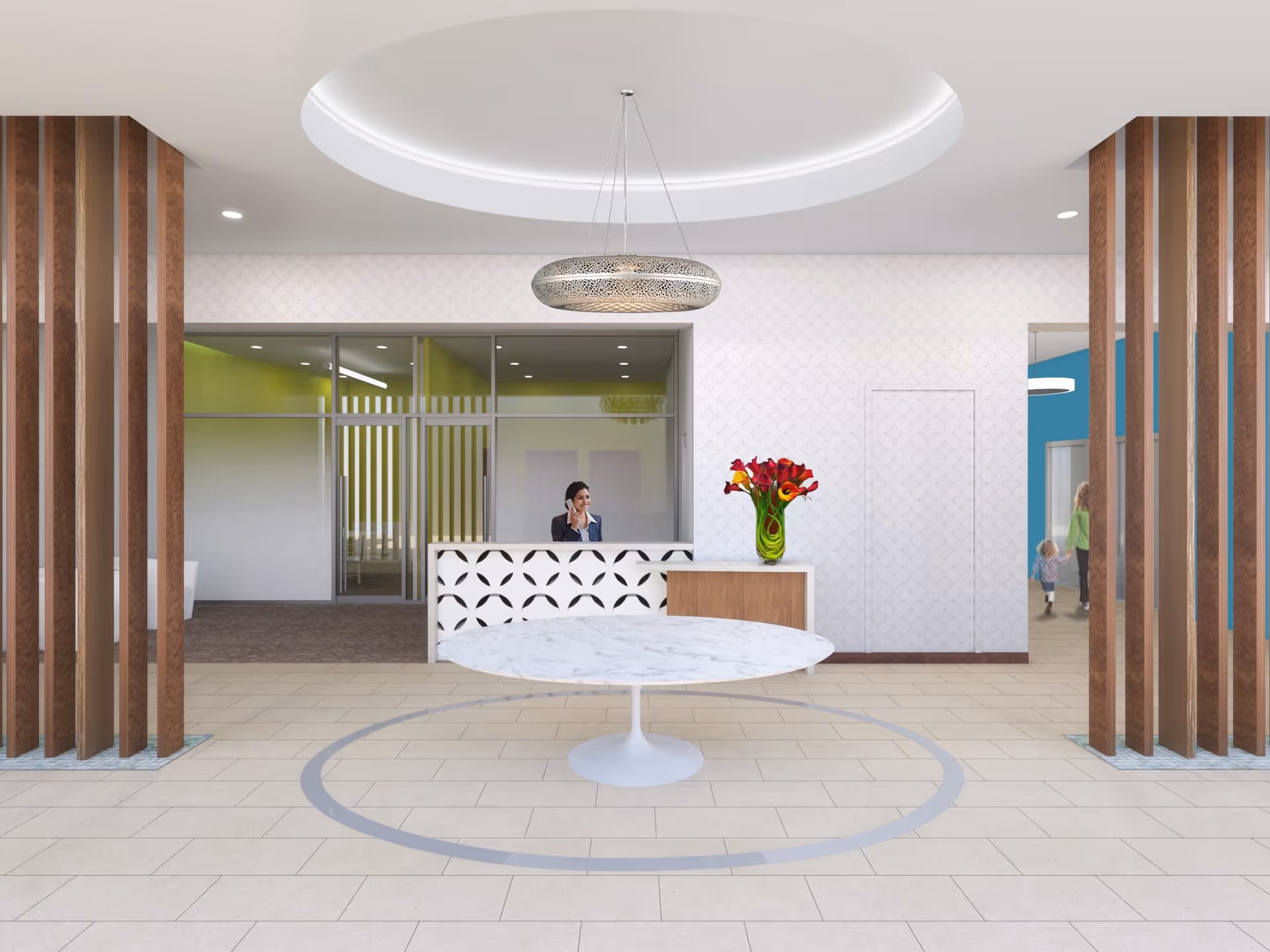 Reception area with a circular marble table in the center, a modern white reception desk with a woman sitting behind it on the phone, a vase with red and yellow flowers on the desk, wooden vertical slats on both sides, and a circular ceiling light fixture above.