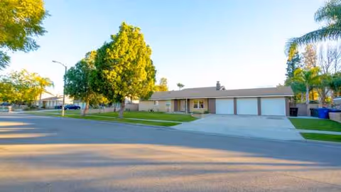 Front view of Annie's Haven senior living facility with driveway, garages, and trees.