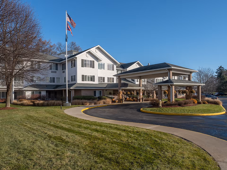 Exterior view of a senior living facility with a porte-cochere and circular driveway.