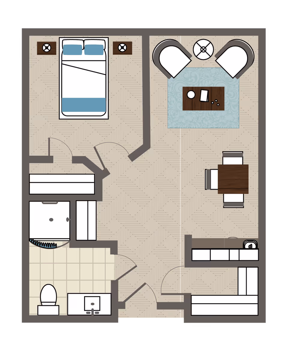 Floor plan of a one-bedroom assisted living unit showing a bedroom with a bed and two nightstands, a living room area with two chairs, a coffee table, a dining table with four chairs, a kitchen with counters and a sink, and a bathroom with a toilet, sink, and shower.