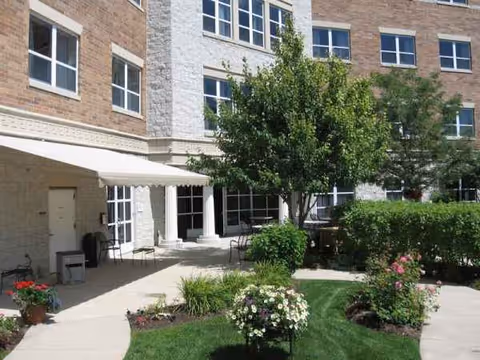Exterior view of Greek American Rehabilitation & Care Centre with entrance courtyard and landscaping.