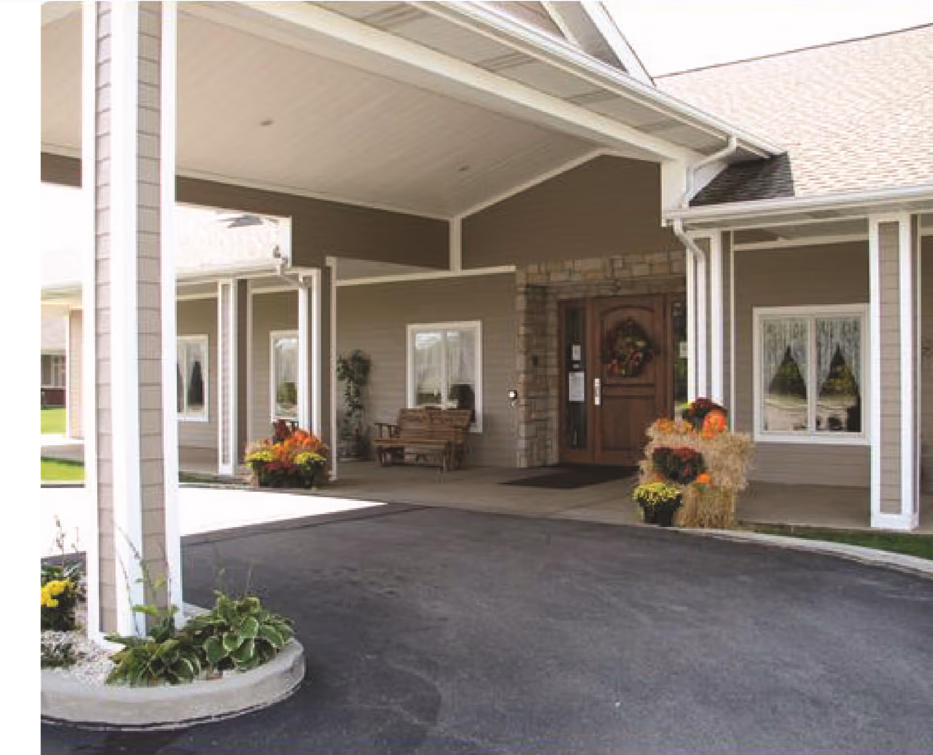 Front entrance of Fountain Park senior living facility with a covered driveway and planters.