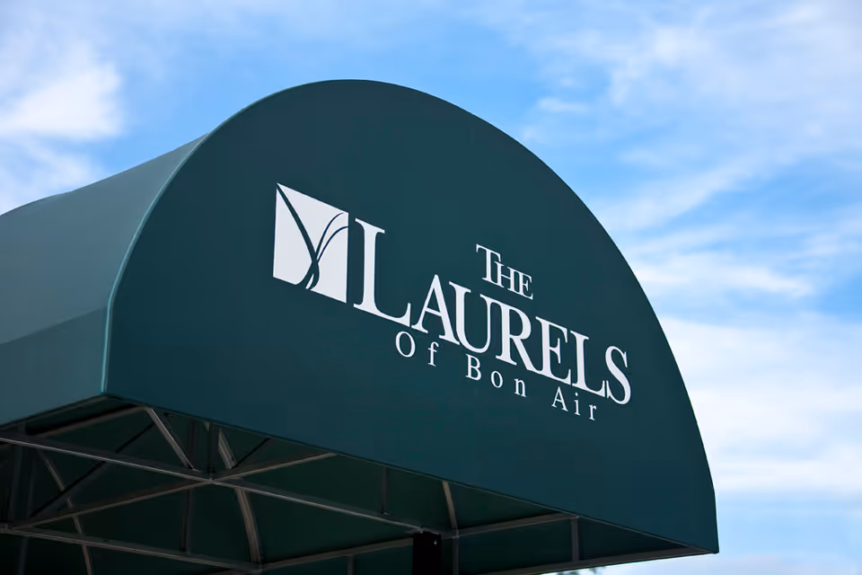 Green entrance awning with white text reading "The Laurels of Bon Air" against a blue sky.