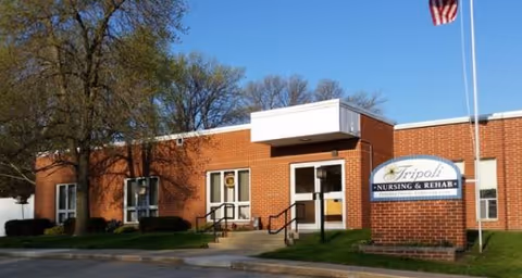 Brick building exterior of Tripoli Nursing and Rehab with entrance and sign.