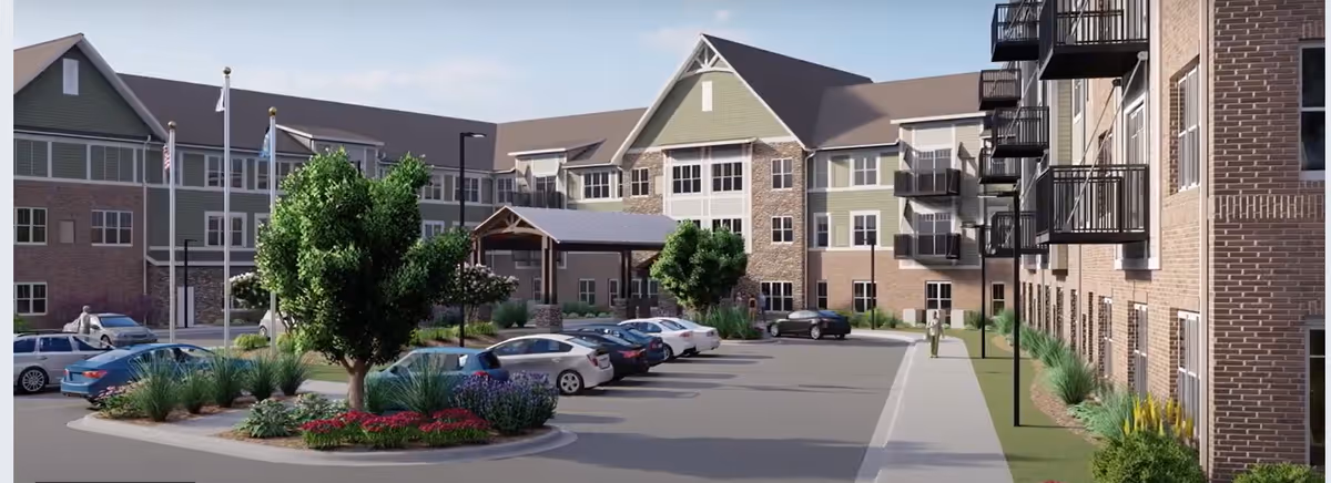 Exterior view of a senior living building with a parking lot, landscaped island, entrance canopy and balconies.