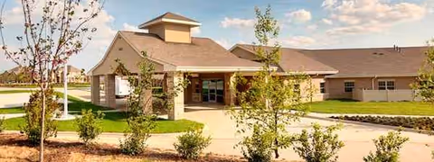 Exterior view of a single-story senior living facility with a welcoming entrance.