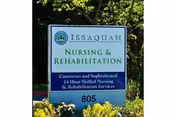 Outdoor sign for Issaquah Nursing & Rehabilitation facility, indicating courteous and sophisticated 24 hour skilled nursing and rehabilitation services, with the address number 805 at the bottom, surrounded by greenery.