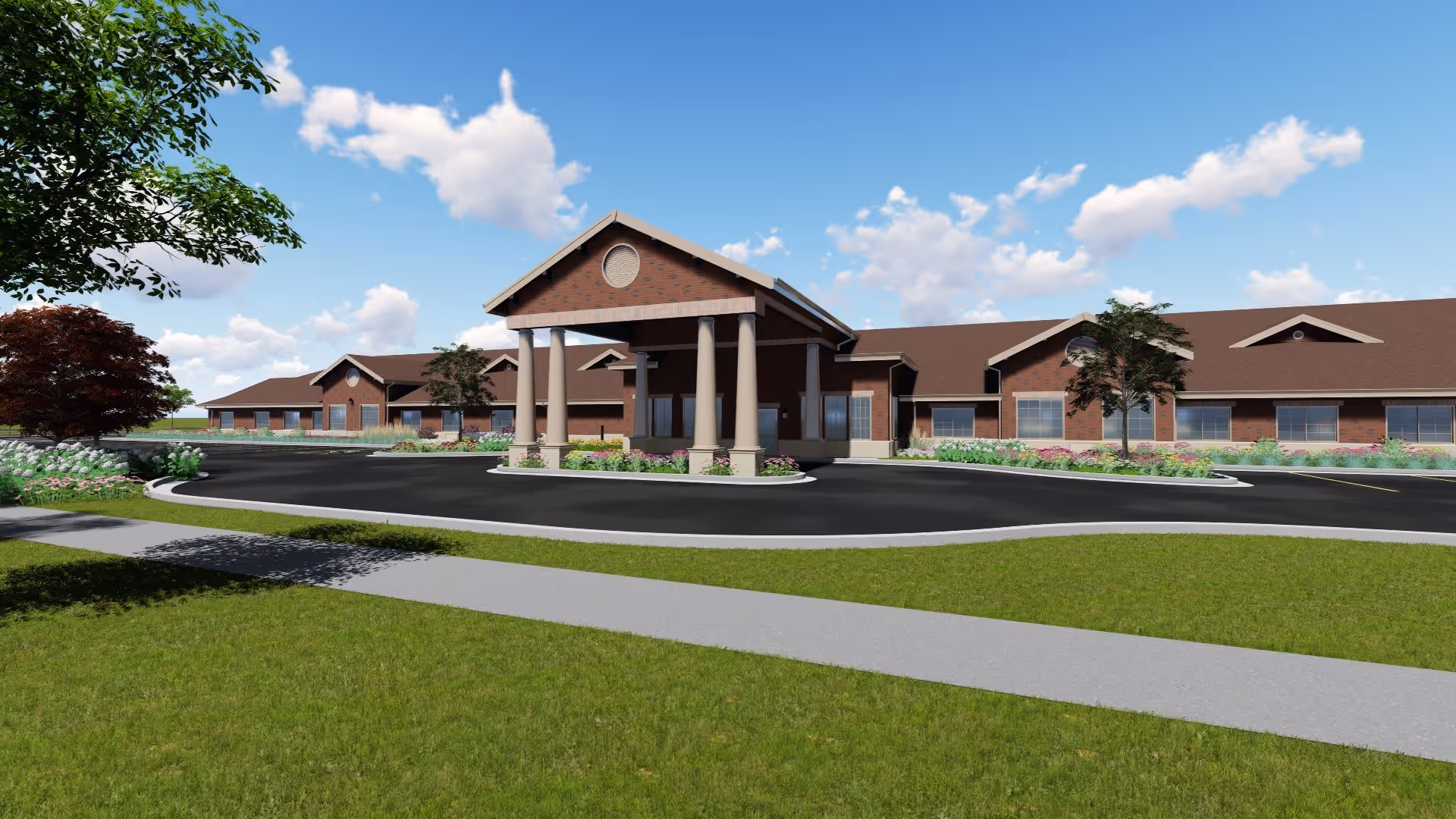 Exterior view of a single-story brick building with a covered entrance supported by columns, surrounded by landscaped greenery and a paved driveway under a blue sky with scattered clouds.