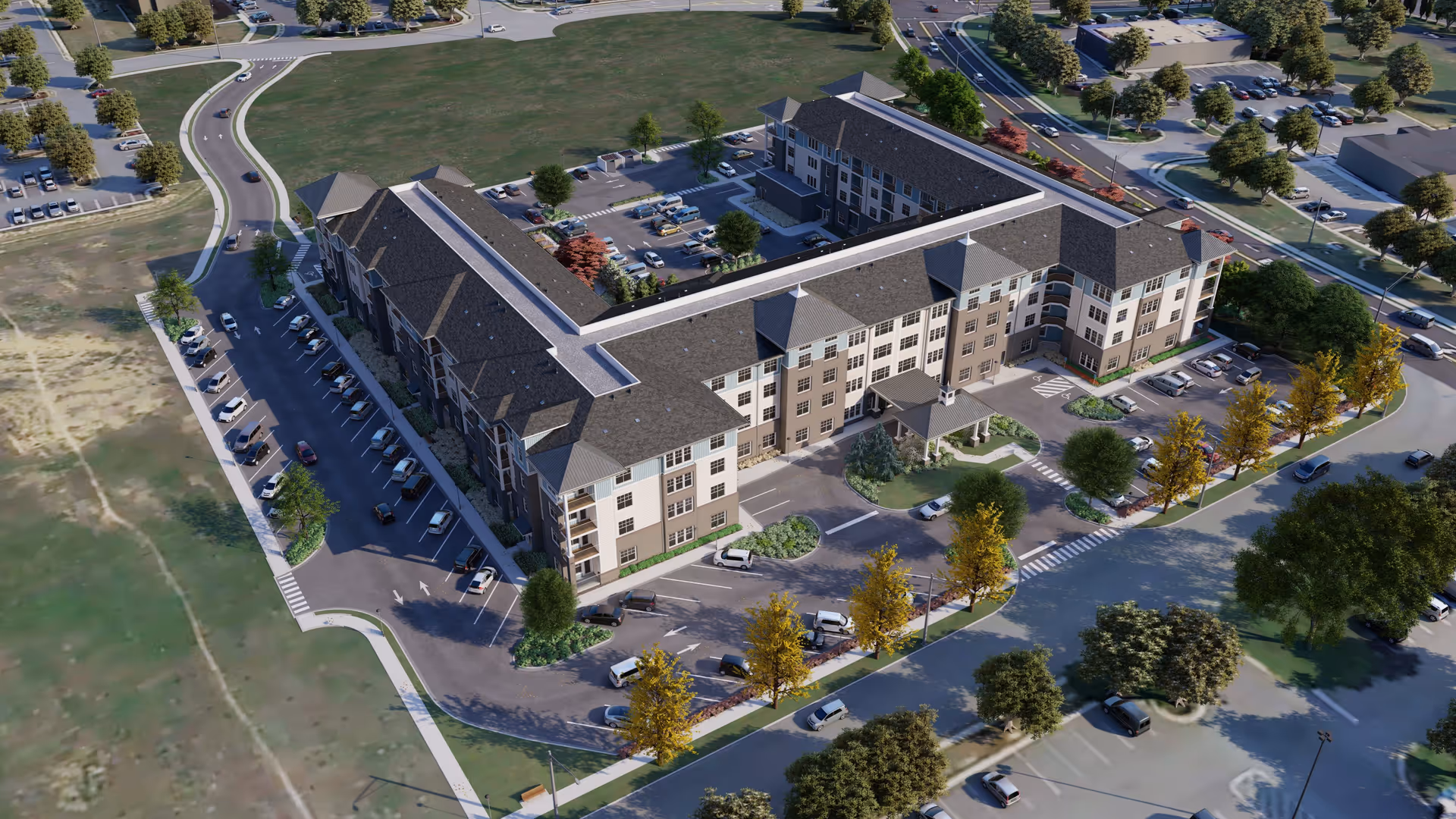 Aerial view of a large senior living facility named Acclaim at The Hill, showing a U-shaped multi-story building surrounded by parking lots, trees, and roads. The building has a dark roof and light-colored exterior walls with multiple windows and entrances. The surrounding area includes landscaped greenery and several parked cars.