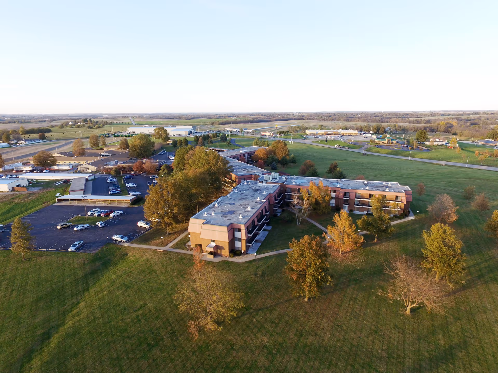 Aerial view of the John Knox Village East building surrounded by lawns, trees, and a parking lot.