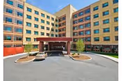 Exterior view of a multi-story rehab center with a covered entrance and circular driveway.