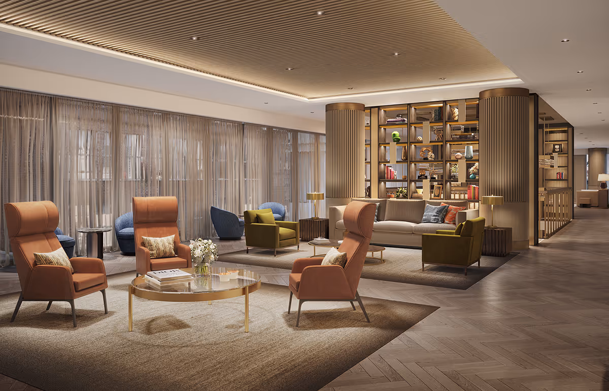 Spacious, modern lounge area with armchairs, sofas, a round coffee table and a decorative bookshelf divider under warm lighting.
