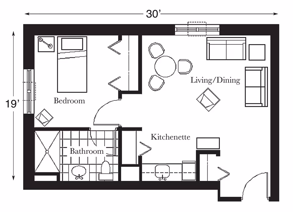 Floor plan of a living space at Churchview Supportive Living showing a bedroom with a bed and chair, a bathroom with a shower, sink, and toilet, a kitchenette with appliances and counter space, and a combined living/dining area with sofas, chairs, and a round dining table.