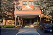 Entrance to Myerstown Nursing and Rehab with orange canopy and driveway.