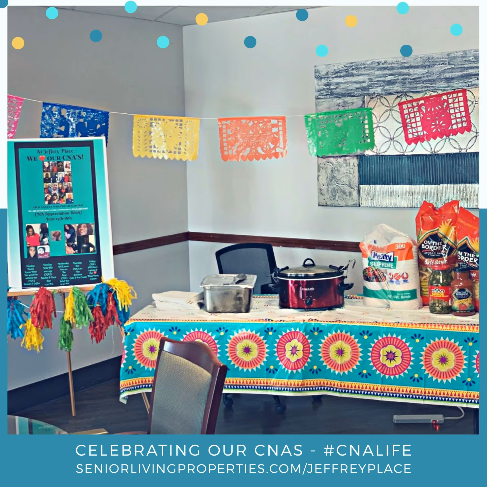 Decorated indoor table with food, a crockpot, chips and colorful papel picado banners for a CNA appreciation event.