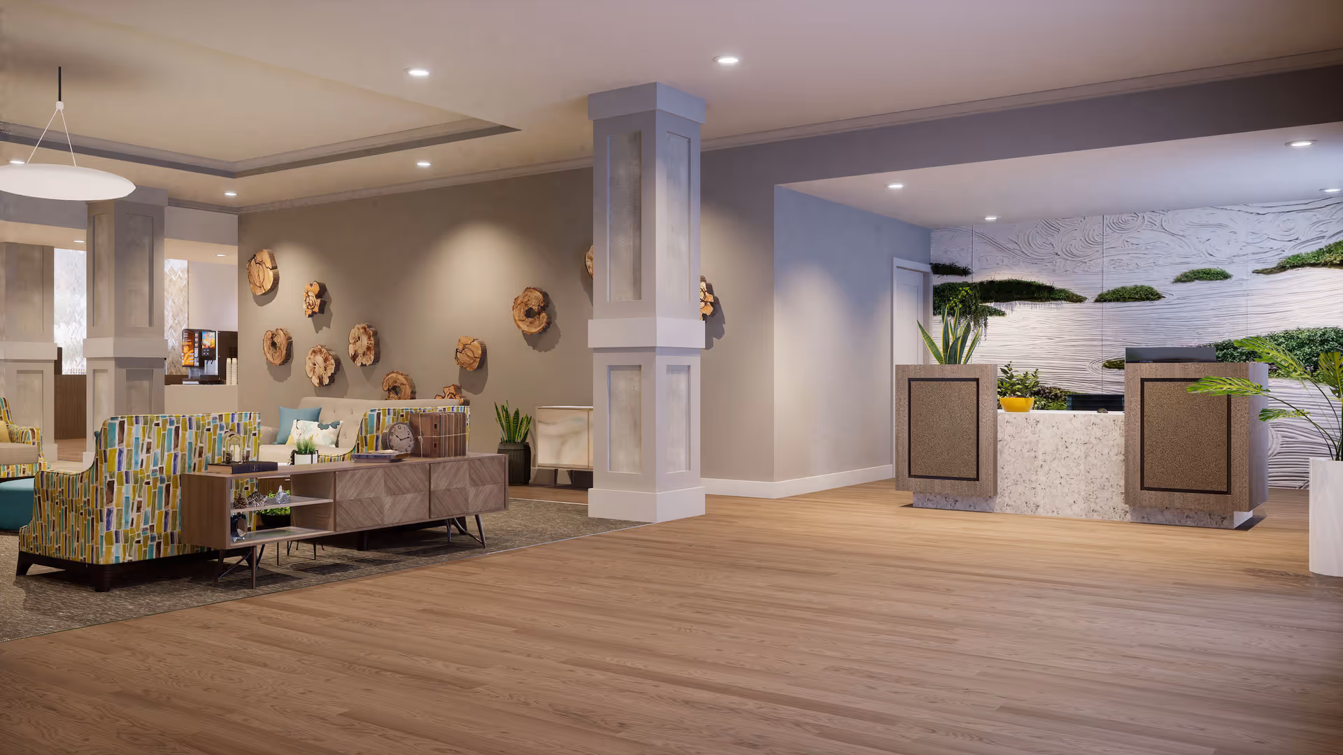 A spacious and modern senior living facility lobby with a reception desk on the right, decorated with plants and textured wall art. To the left, there is a seating area with patterned armchairs, a wooden console table, and wall-mounted wooden art pieces. The floor is light wood, and the ceiling has recessed lighting.
