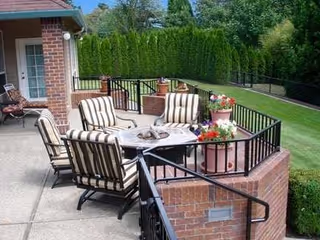 Outdoor patio at The GoodLife Adult Family Home with striped cushioned seating and potted plants