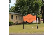 Orange Health & Rehabilitation Center sign on a lawn in front of a single-story building and trees.