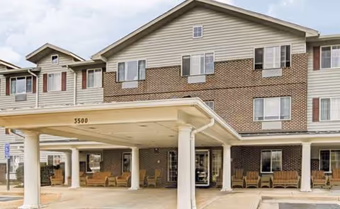 Exterior view of Paramount Senior Living at Manassas with covered entrance and seating.