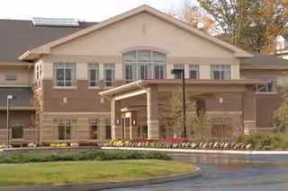 Front exterior view of Cedar Crest senior living facility with entrance canopy and landscaping.