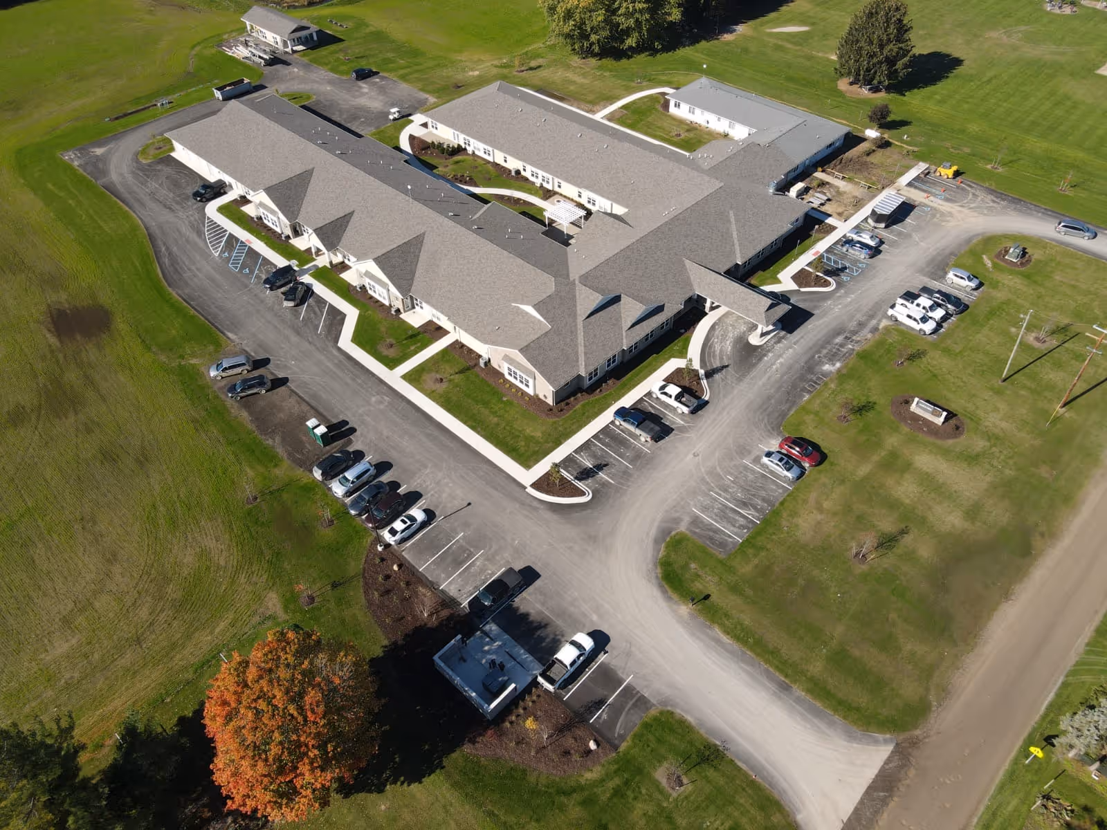 Aerial exterior view of a single-story retirement community building with surrounding parking lots and lawns.