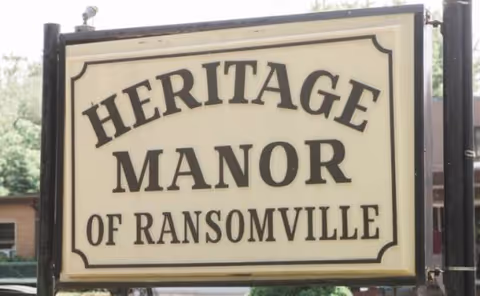 Outdoor sign reading Heritage Manor of Ransomville outside the senior living facility.