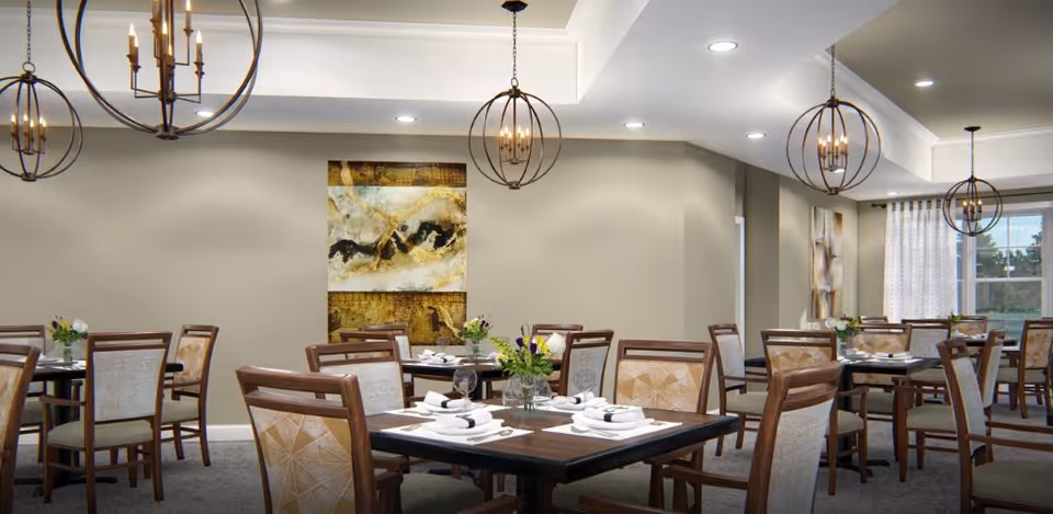 Well-lit dining room with multiple tables set for meals, wooden chairs, hanging spherical chandeliers, and abstract wall art.