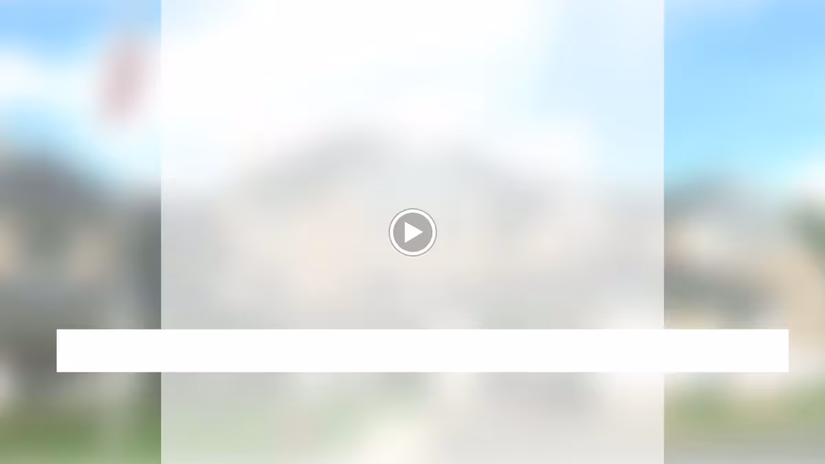 Blurred exterior view of a building with a central video play icon and a white horizontal bar overlay.