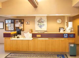 Reception desk with a staff member in a hospital lobby.