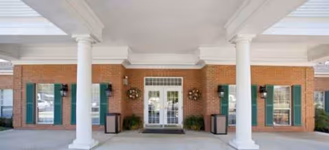 Front entrance of Brookdale Hampton Cove, a brick senior living facility with white columns.
