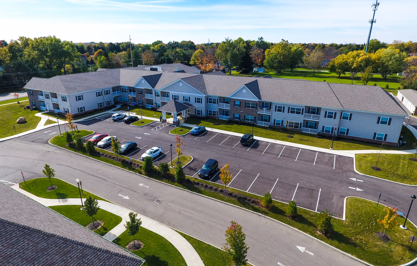 Aerial view of a two-story senior living building with a parking lot and landscaped grounds.